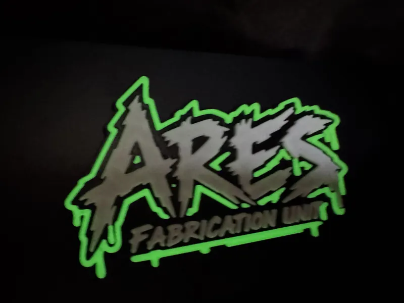 The ARES Fabrication Unit sign glowing at dusk
